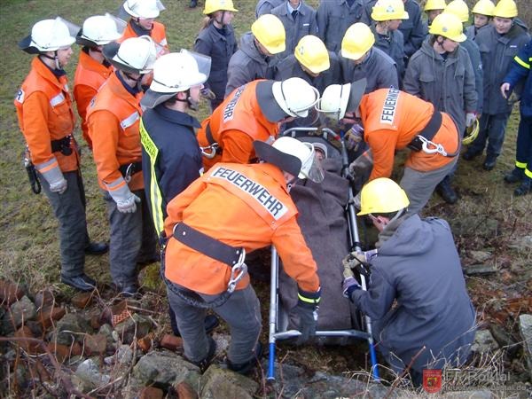 Bild 6 von 25 Die Person wurde geborgen und zum Transport auf die Trage gelegt. Die herumstehenden Jugendlichen werden anschlie&szlig;end f&uuml;r das Bilden einer Menschenkette gebraucht.