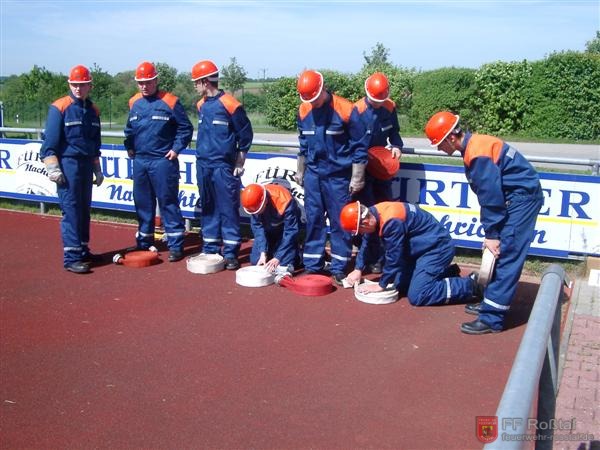 Bild 6 von 15 Zweite &Uuml;bung: "Schnelligkeits&uuml;bung"Es m&uuml;ssen acht C-Schl&auml;uche in einer vorgegebenen Zeit ausgerollt und zusammengekuppelt werden. Die Schl&auml;uche d&uuml;rfen nicht in sich verdreht sein. 